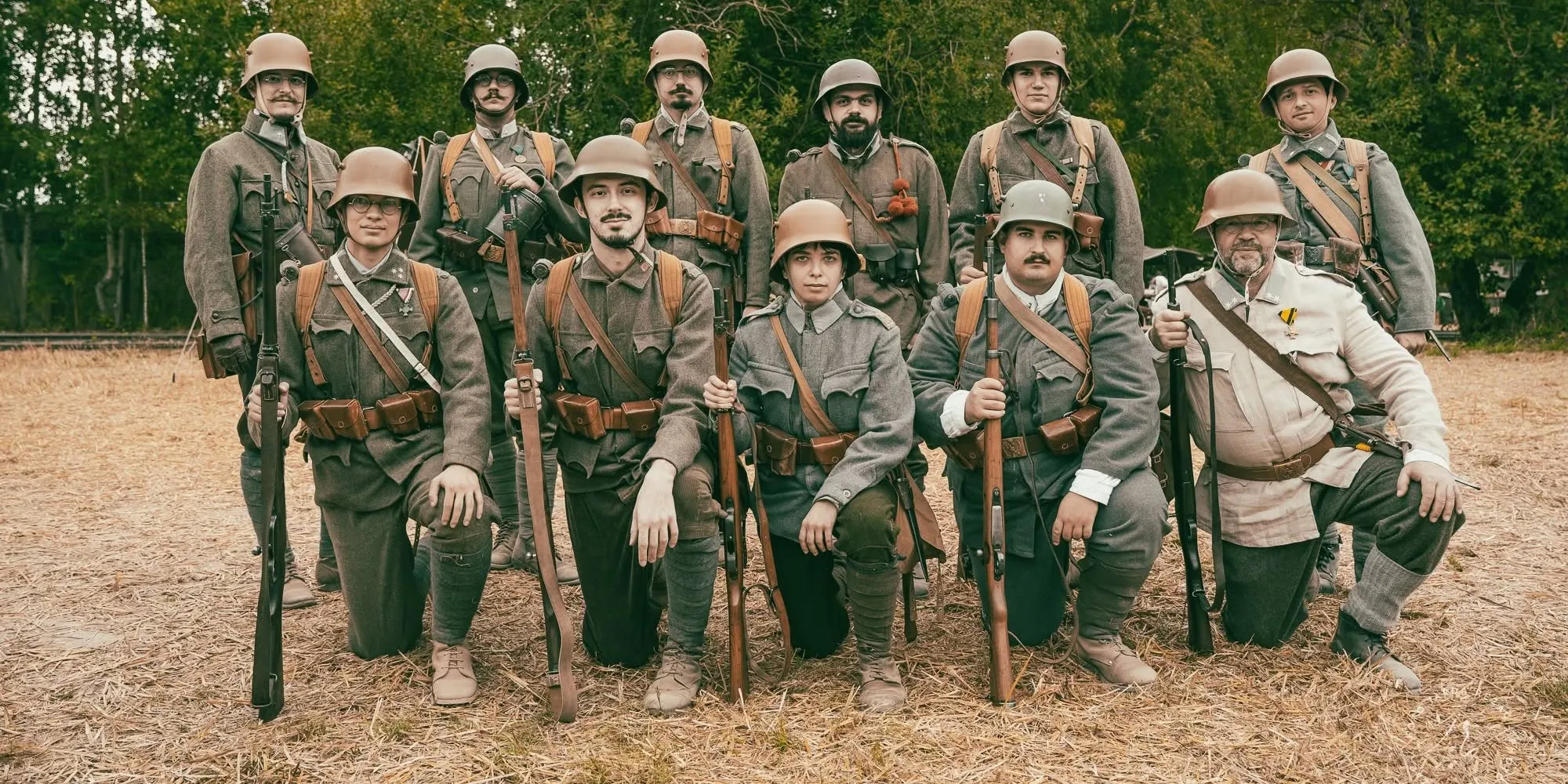 Historical reenactors posing together outdoors in military uniforms.